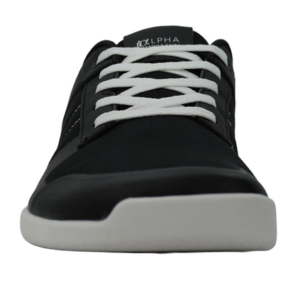 Chaussures minimalistes noires et blanches de type barefoot, parfaites pour un confort pieds nus.